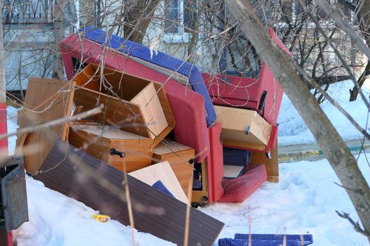 Old furniture thrown in the trash near the street trash cans. High quality photo