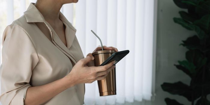 Close up businesswoman using smartphone at home office.