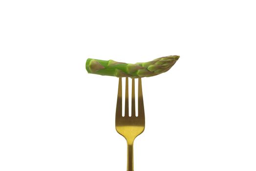 Asparagus pinned on a golden fork isolated on a white background