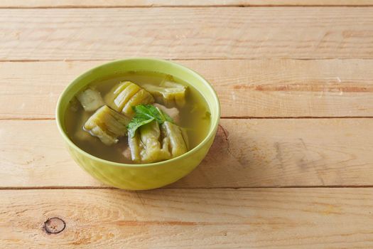 Bitter gourd soup with pork ribs in bowl on wood table