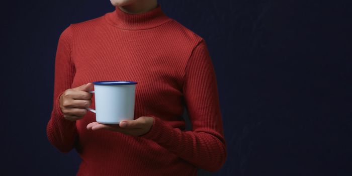 Women wearing fashion dresses is holding big cup on dark background