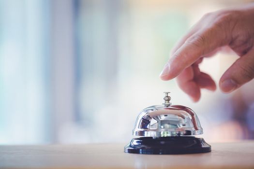 Bell on counter for service with hand. Ring the bell