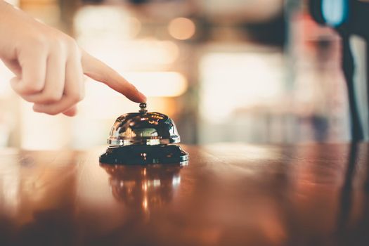 Bell on counter for service with hand. Ring the bell