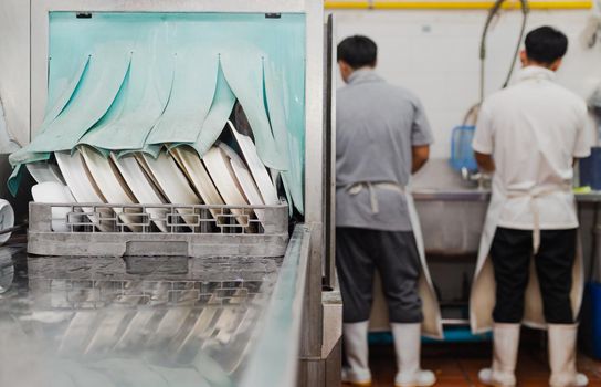 Man washing dish on sink at restaurant