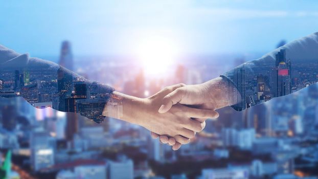 Double exposure handshake of business on city background