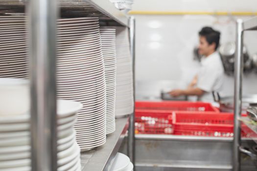 Man washing dish on sink at restaurant