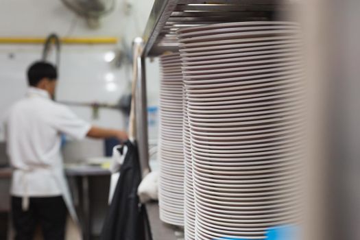 Man washing dish on sink at restaurant