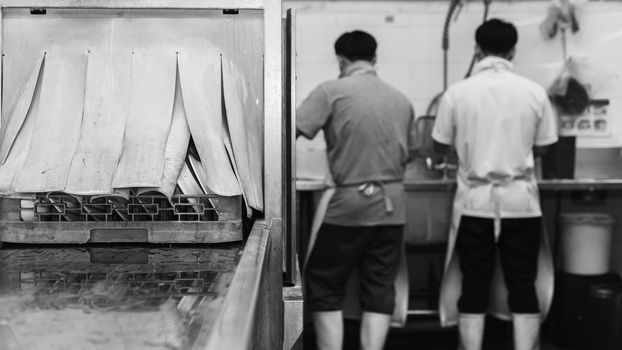 Man washing dish on sink at restaurant