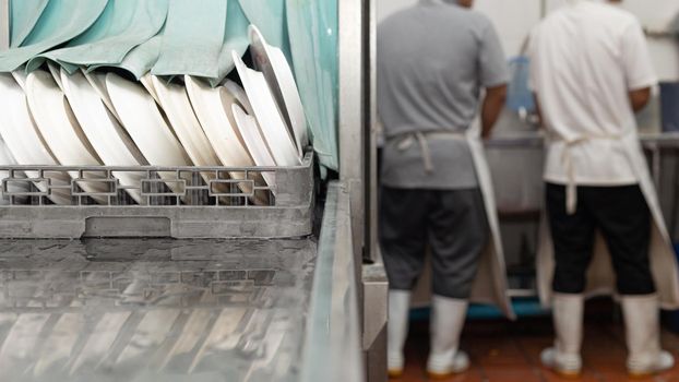 Man washing dish on sink at restaurant