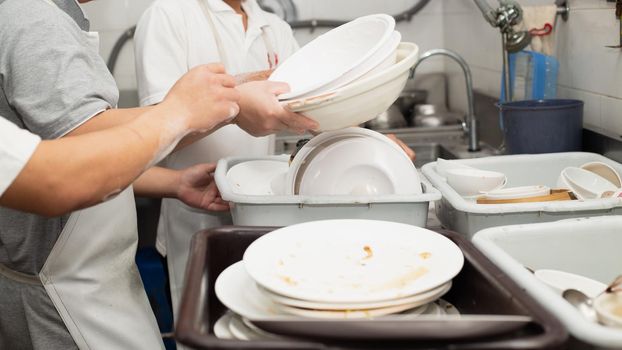 Man washing dish on sink at restaurant