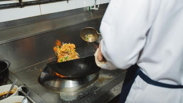 Chef stir fry busy cooking in kitchen