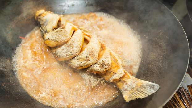 Snapper Fish with brown sauce boil on iron pan