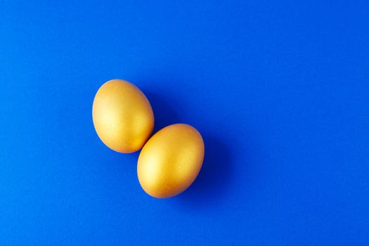 Couple Eggs Easter golden on blue background