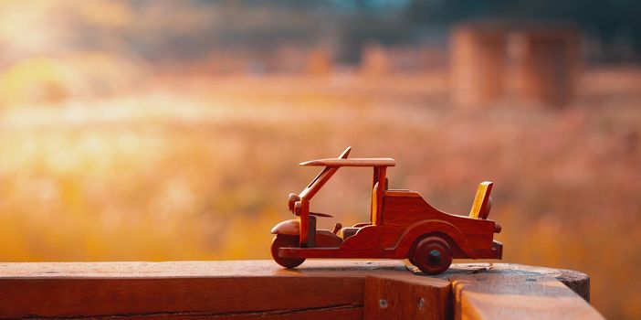Three wheel taxi wooden toy on garden with morning sunlight. Tuk Tuk Thailand. Panoramic photo