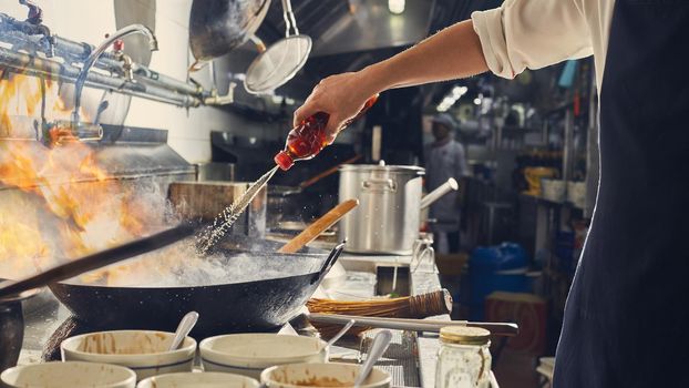 Chef stir fry cooking in kitchen