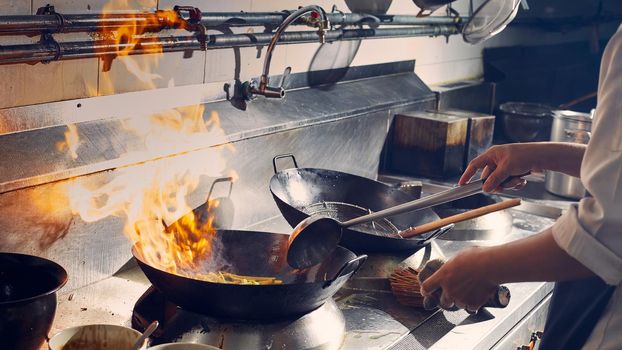 Chef stir fry cooking in kitchen