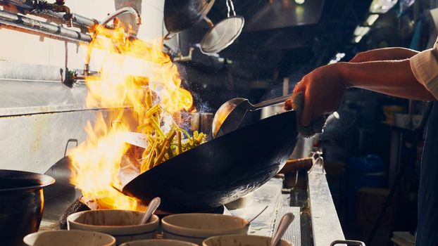 Chef stir fry cooking in kitchen