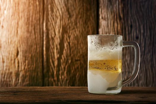 Beer in mug on wooden table with wooden background