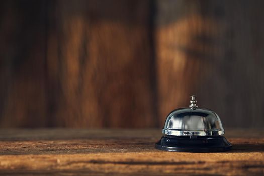 Bell on wood for service with blurred wooden background