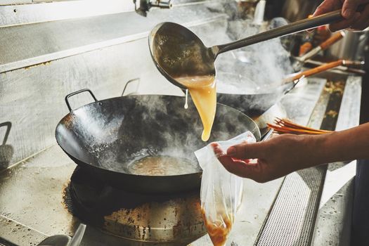 Chef stir fry cooking in kitchen