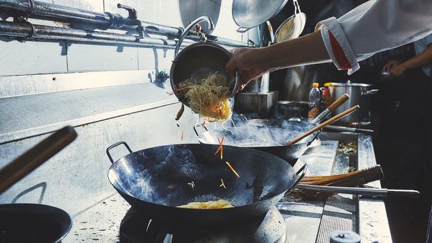 Chef stir fry cooking in kitchen