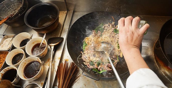 Chef stir fry cooking in wok at kitchen, Take photo on top view