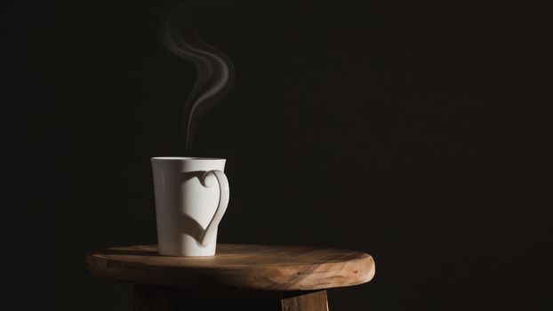 Shadow heart shape  of love with coffee cup on dark background