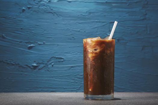 Ice coffee in glass on rough background