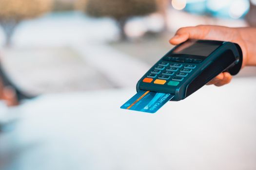 Paying via a credit card swipe machine, new normal shopping concept