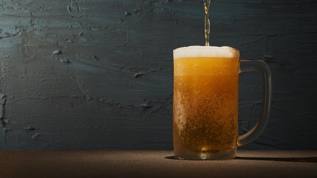 Cold beer in mug on the table with rough background