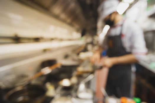 Blurred chef cooking in kitchen for background