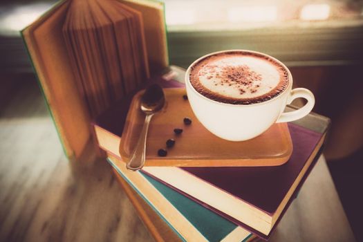 Cappuccino coffee cup on book in coffee shop