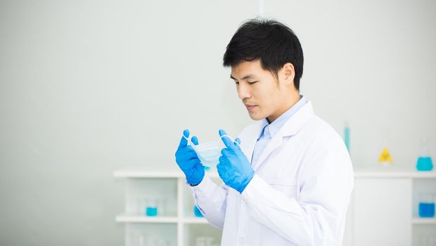 Medical personnel are wearing or removing a mask before entering a medical laboratory