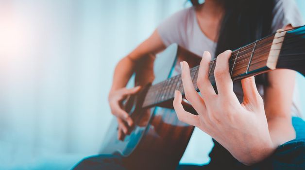Women practice playing acoustic guitar with determination, Photo with hipster filter