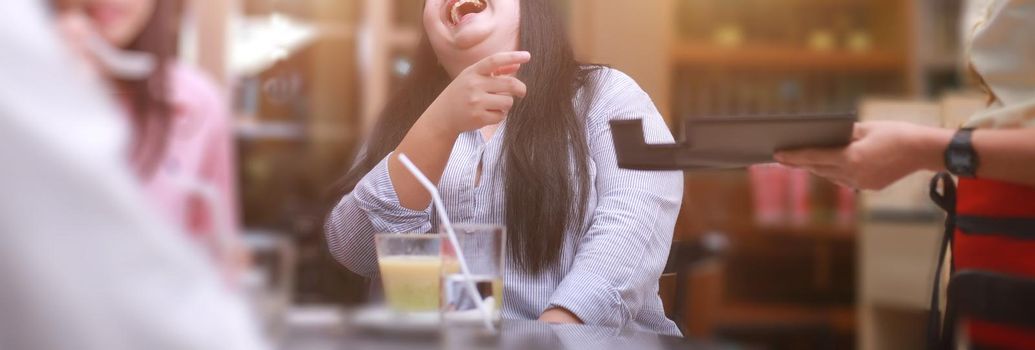 Woman and friend smiling and happy to pay the bill in the restaurant. Banner size photo