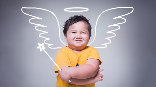 Little cupid of love concept with smiling cute kid. Asian kid on gray background