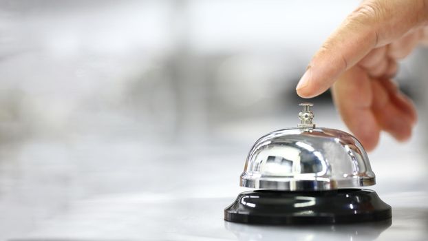 Bell on counter for service with finger customer for call on blurred background, Service concept