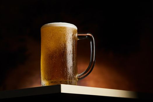 Beer in mug on wooden table with wooden background