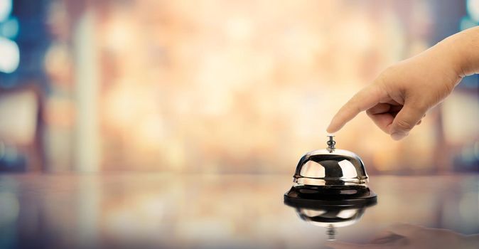 Bell on counter for service with hand on blurred background