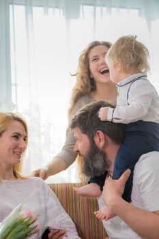 Dad with children congratulate mom on the holiday, mother's day. Have fun, laugh and give flowers