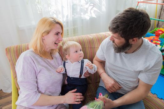 Dad with children congratulate mom on the holiday, mother's day. Have fun, laugh and give flowers