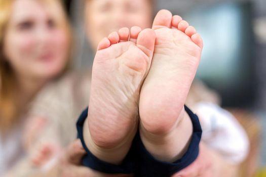 The whole family, parents and children hold the baby's heels in the palms of the hands.