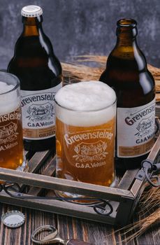 Hamburg, Germany, March 27.2021. Grevensteiner beer, mug and bottle of beer with wheat ears on wooden planks.