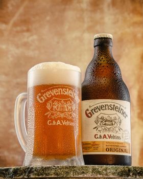Hamburg Germany,March 21, 2021. Grevensteiner Beer. Mug and bottle of cold beer with water drops.