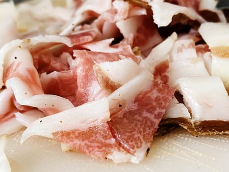 Guanciale cut into small pieces to season the carbonara pasta. Typical Italian food. Pork cheek. Meat and seasoning