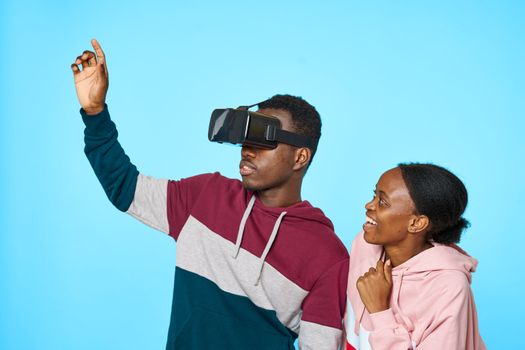 3D virtual reality glasses on the face of an African man and woman on a blue plan