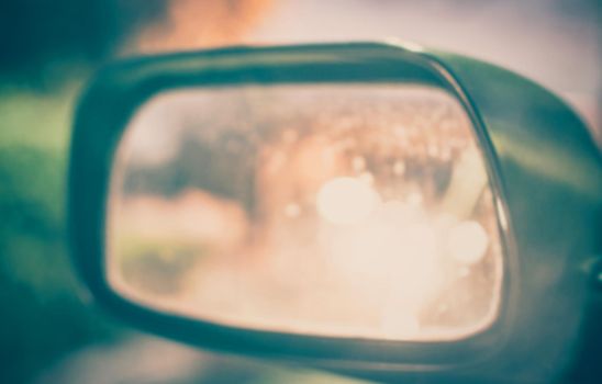 Vintage Style - blurred luxury car on road with side mirror.