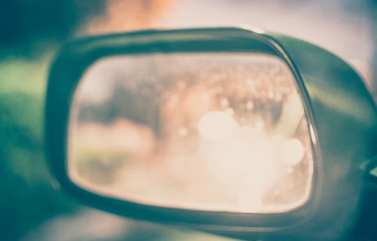 Vintage Style - blurred luxury car on road with side mirror.