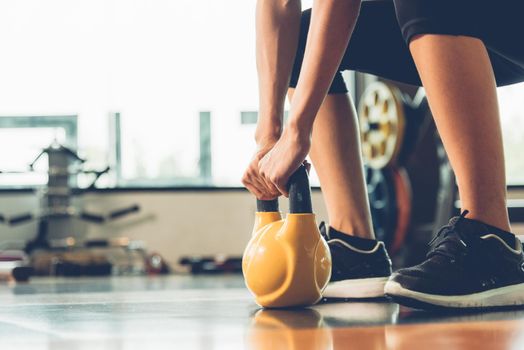 Beautiful woman using dumbbell weights workout at fitness GYM