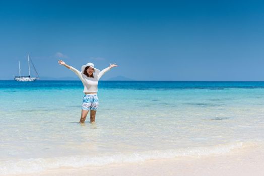 Happy woman on the beach relaxing joyful in summer with tropical blue water at Koh rok, Thailand